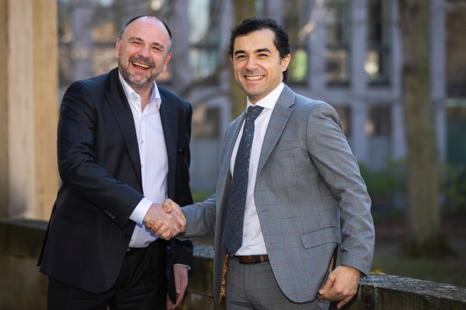 Ufuk Akcigit shaking hands with the President of the Halle Institute for Economic Research outside the IWH building in Halle.